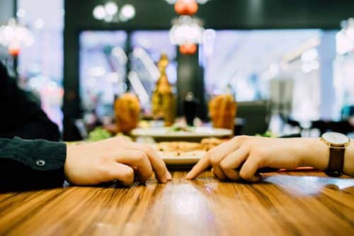 Deux personnes sur le point de se toucher la main dans un restaurant